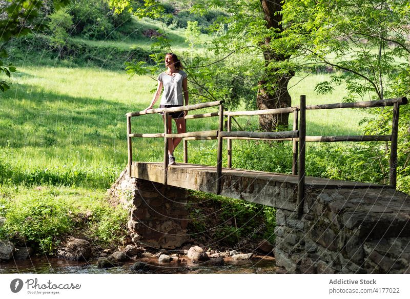 Woman relaxing on bridge in forest woman woods summer river enjoy carefree nature female peaceful tree stand freedom water creek brook old tranquil calm