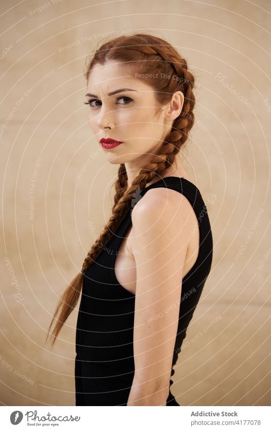 Woman with braids in studio looking at camera redhead hairstyle woman appearance charming trendy red hair female red lips model personality individuality