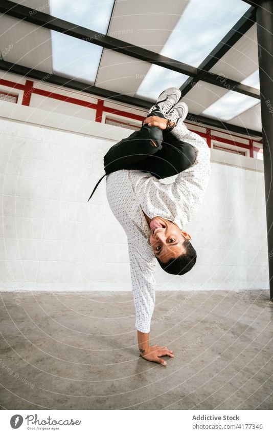 Male break dancer performing handstand man trick acrobatic energy move style active young male activity lifestyle skill modern practice balance talent agile