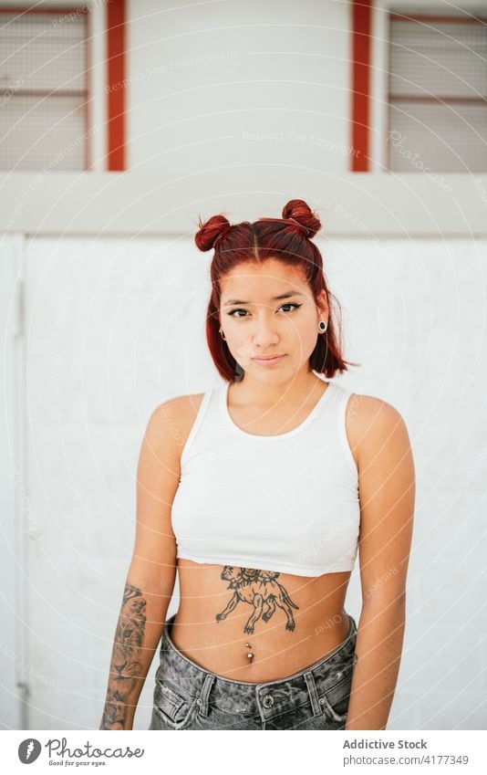Young ethnic woman with tattoos looking at camera alternative piercing style informal break dance young modern subculture female lifestyle slim trendy