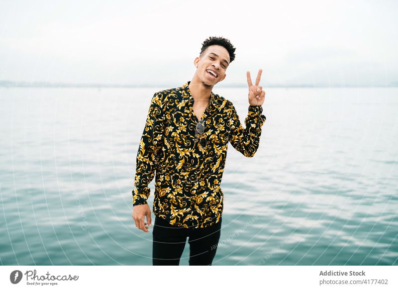 Happy black man showing peace sign two fingers gesture victory symbol v sign cheerful sea male ethnic african american glad smile optimist style joy positive