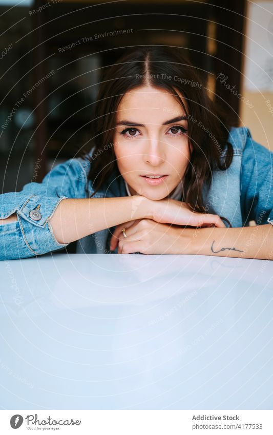 Smiling woman in denim jacket looking at camera young brunette tattoo calm smile hipster rest positive female relax optimist millennial content casual modern