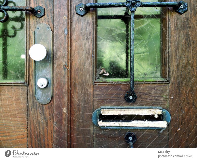 Improvised mailbox slot in a beautiful old wooden house door in Oerlinghausen near Bielefeld in the Teutoburg Forest in East Westphalia-Lippe Mailbox