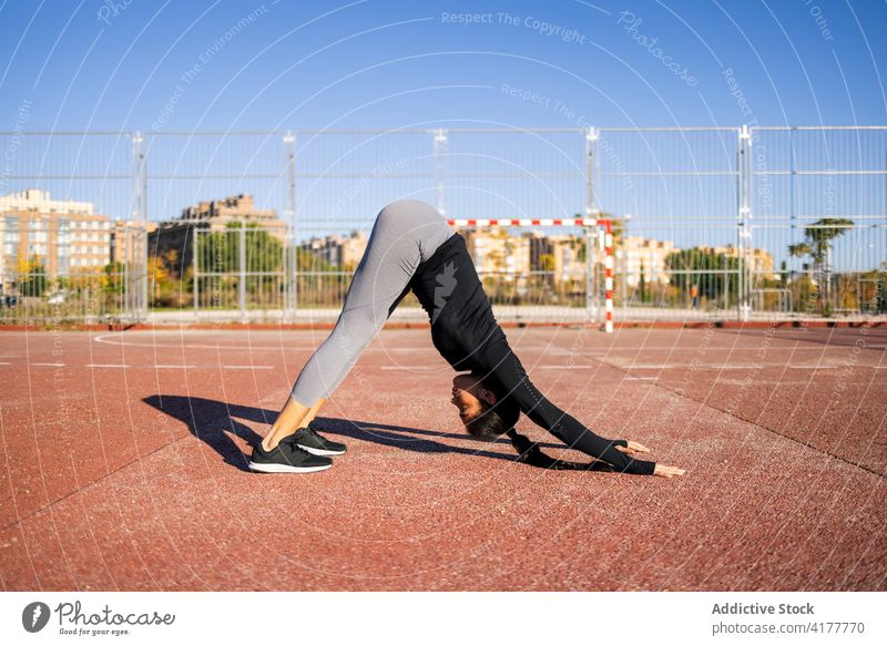 Woman doing downward facing dog during yoga exercises woman training Adho mukha svanasana practice balance flexible acrobatic female gymnastic athlete workout