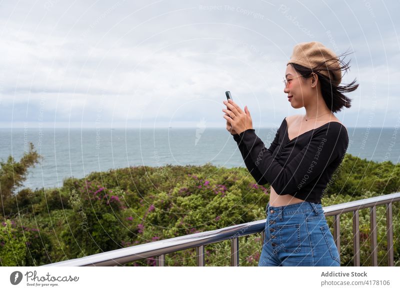 Young woman taking photo of seascape take photo smartphone traveler viewpoint mobile capture ocean photography shoot digital nature tourist enjoy happy young