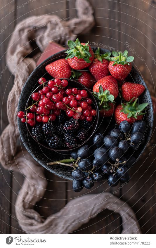 Delicious fruits and berries in bowl on table harvest berry various rustic healthy old sweet kitchen towel tasty natural meal nutrition strawberry grape
