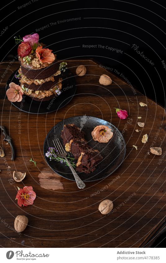 Tasty chocolate cake with walnuts served on table flower piece rustic dessert sweet food festive cut pastry naked cake gourmet confectionery delectable