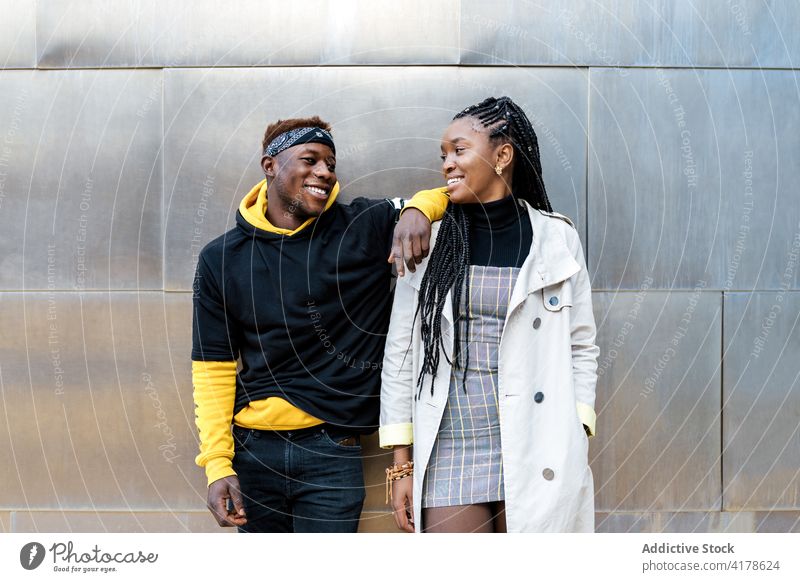 Stylish black man and woman standing near modern building couple trendy style pensive thoughtful urban fashion millennial hipster young african american ethnic