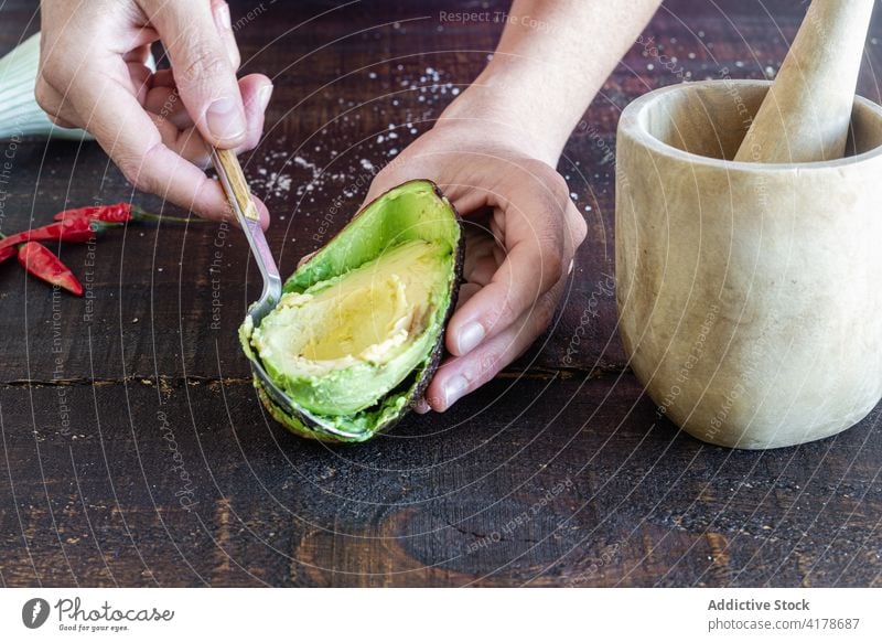 Woman taking seed from avocado guacamole ingredient prepare half recipe food fresh tradition mexican cuisine vegetable meal vegetarian spoon hand pestle mortar