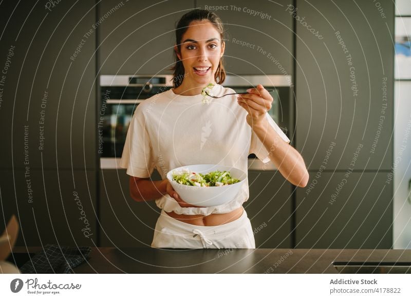 Charming woman with bowl of healthy salad healthy food diet vegetable kitchen lunch content female fresh cheerful nutrition happy meal dish cuisine yummy