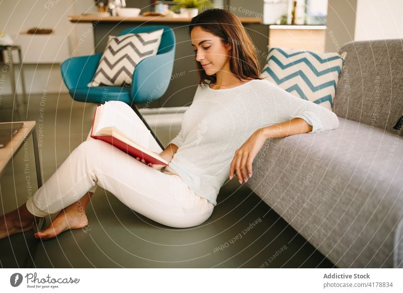 Woman reading book in living room woman at home rest sofa weekend cozy young free time literature female interesting couch relax story novel lifestyle comfort