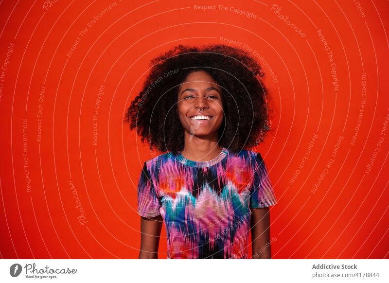 Charming black woman in vivid dress in studio cheerful bright laugh colorful trendy fun fashion toothy smile millennial ethnic afro african american cuban