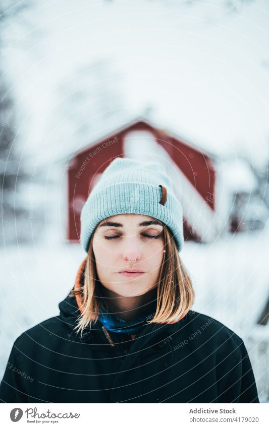 Tranquil woman in warm clothes enjoying winter tranquil nature wintertime cold snow white female outerwear village serene eyes closed peaceful countryside calm