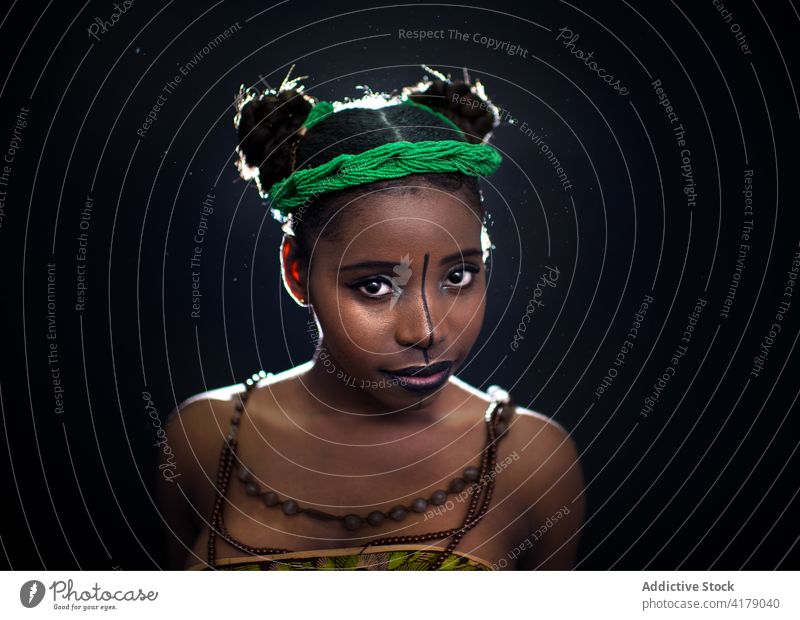 Young black woman with painted face fashion style facial tradition colorful african headband portrait model body art ethnic young female appearance vivid afro