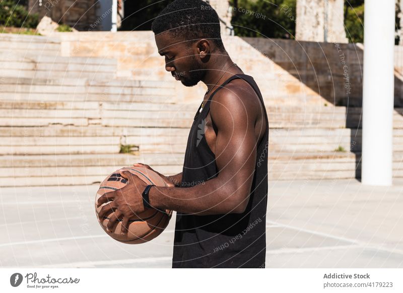 Serious black man with basketball on sports ground player determine summer sunglasses male ethnic african american sportswear style confident recreation serious
