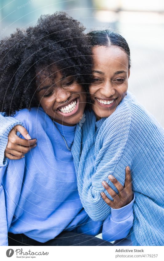 Delighted black girlfriends resting on bench cheerful together happy cuddle similar enjoy best friend young women african american afro ethnic close