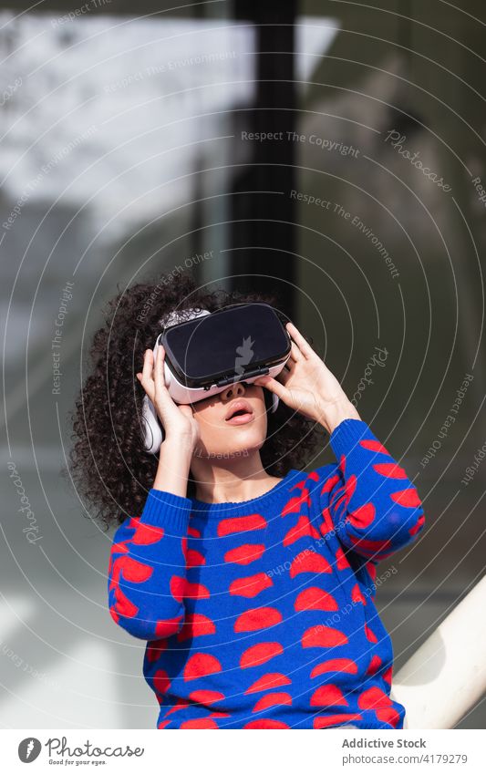 Cheerful woman in VR glasses riding roundabout on playground vr virtual reality experience excited thrill female goggles innovation modern headset having fun