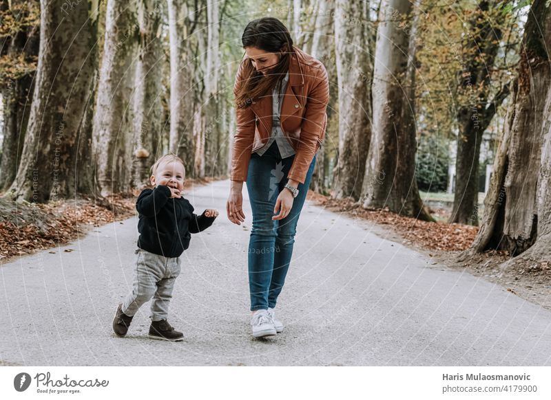 Young mom with little boy outdoors with text happy mothers day 1 year old 1 year old baby 2020 adult autumn beautiful caucasian cheerful child combination cute