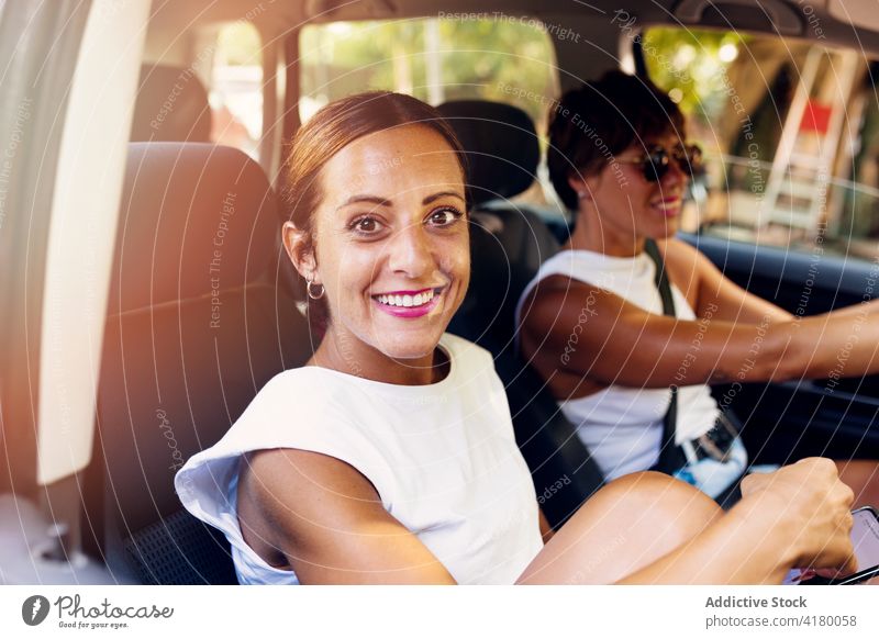 Women sitting in car and smiling at camera women friend cheerful friendship company summer enjoy weekend people friendly automobile optimist glad together