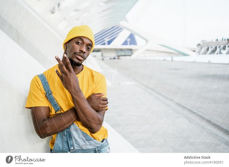 Black man showing rude shocker gesture in city symbol sexual sign finger trendy male ethnic black african american yellow street outfit style behavior rebel