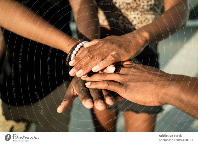 Company of black people stacking hands together stack hands friendship unity gather company collaborate ethnic african american community daytime partner union
