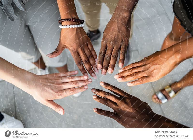 Company of multiethnic people stacking hands together friendship unity gather company collaborate black african american community partner union interact