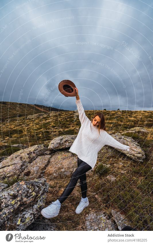 Woman holding hat in mountains woman enjoy vacation summer highland carefree freedom female traveler trip tourism holiday nature terrain wanderlust happy