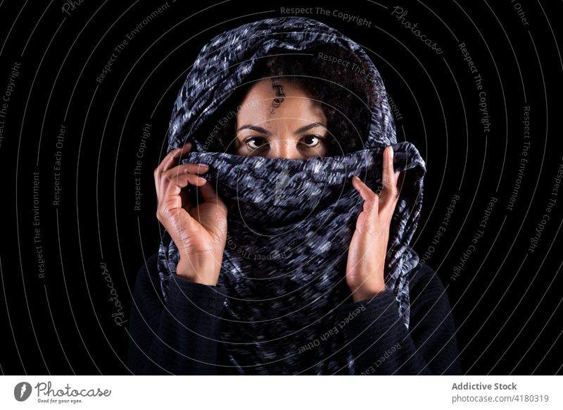 Ethnic woman covering face with headscarf cover face hide ethnic concept serious portrait fear culture young female black african american eye lifestyle abuse