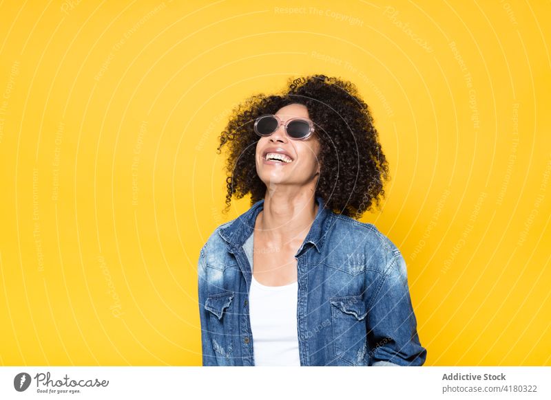 Cheerful ethnic woman in denim shirt looking away sunglasses cheerful smile casual positive trendy happy optimist curly hair young african american black afro