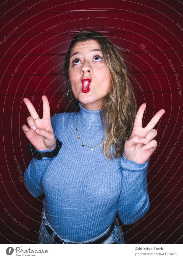 Funny woman showing two fingers in photo booth gesture peace grimace funny coquette humor playful childish personality female v sign victory symbol demonstrate