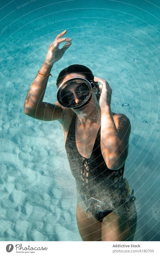Woman swimming underwater in sea woman flipper dive swimsuit grace slim undersea female swimmer swimwear summer diver turquoise color deep bottom sand lady