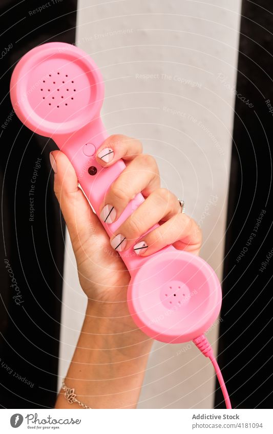 Woman with stylish manicure holding retro telephone hand pink style design color nail woman fashion female elegant receiver old fashioned vintage feminine