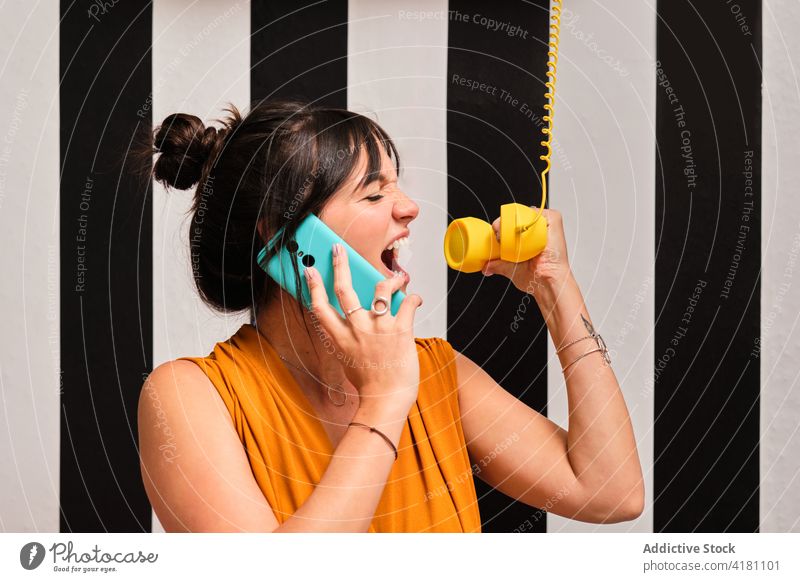 Funny woman with smartphone and retro telephone receiver communicate device listen talk shout scream funny young female call gadget mobile connection