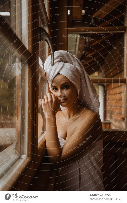 Charming woman in towels reflecting in hut window touch face feminine gentle tender reflection cabin idyllic wooden charming harmony calm shack serene terry