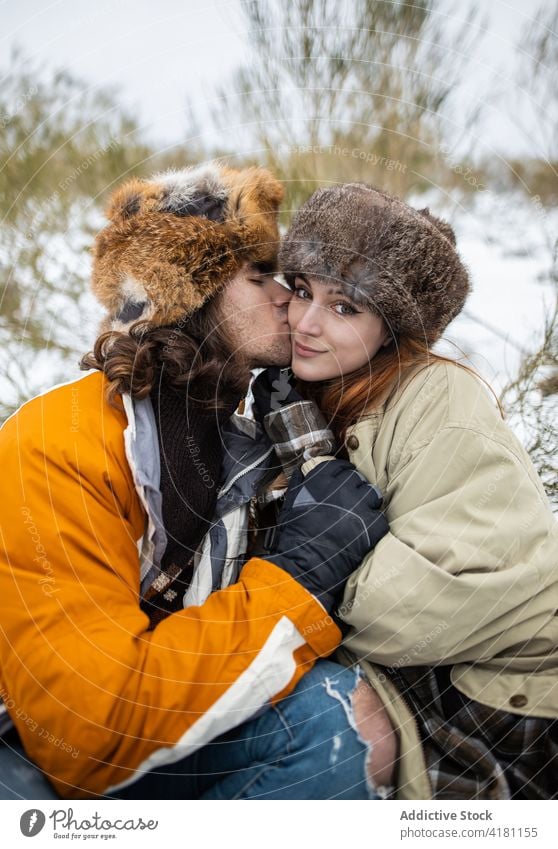 Couple in fur hats embracing against snowy mountain couple embrace love relationship spend time weekend tourism winter harmony boyfriend girlfriend enjoy sit