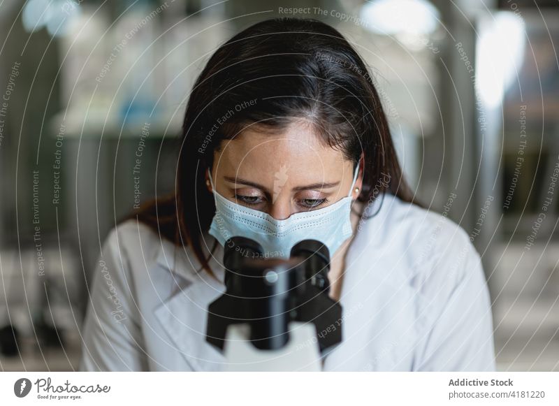 Scientist examining test samples through microscope scientist laboratory examine analyze equipment investigate using research experiment woman chemical modern
