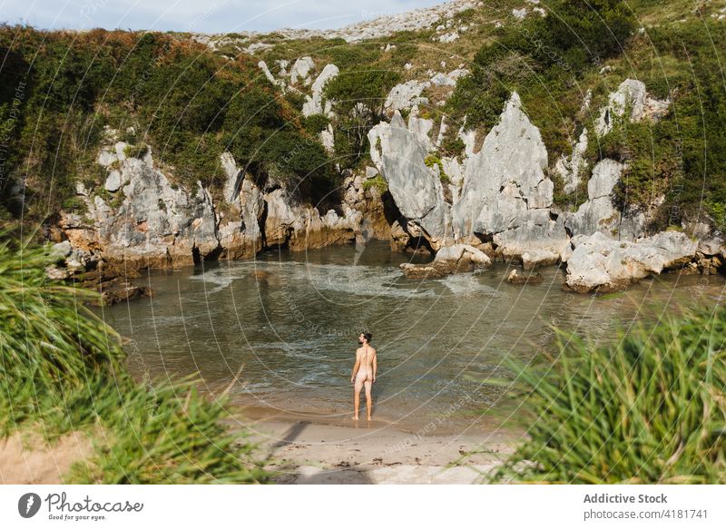 Naked man standing on lakeside in rocky highlands beach naked rough nudism cliff undress pond nude scenic nature asturias spain shore coastline bare male