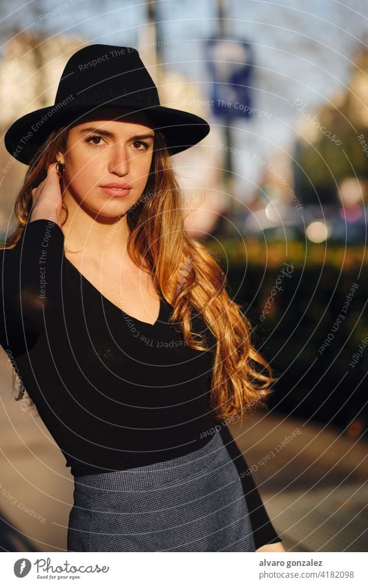 Portrait of young woman posing outdoors. urban street sombrero style city closeup clothing outside one pose confident casual long hair looking lifestyle