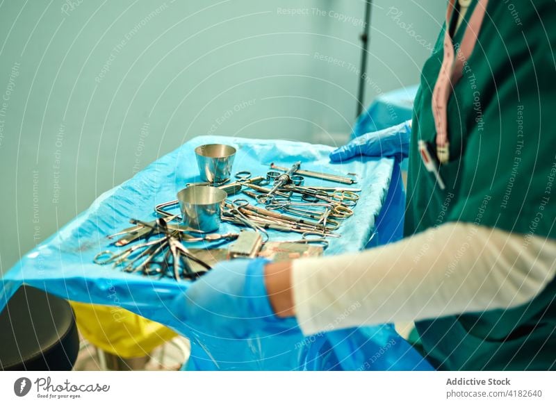 Unrecognizable nurse taking various instruments during surgery in operating room choose hospital surgeon work assistant doctor clinic carry job sterile field