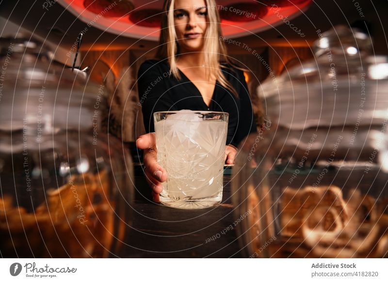 Smiling young woman serving refreshing cocktail in bar serve smile bartender alcohol beverage drink content restaurant refreshment female long hair blond cold