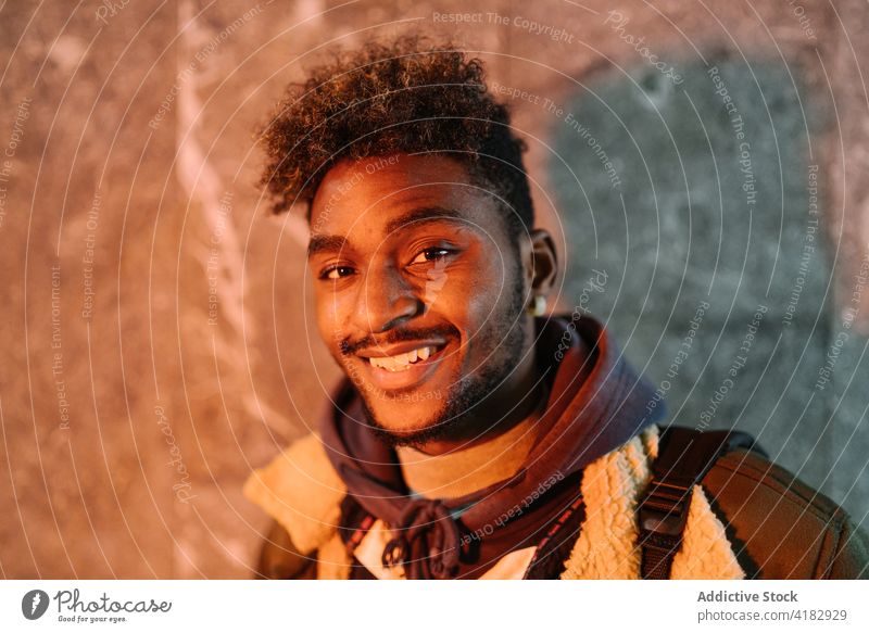 Cheerful ethnic man in warm outfit looking at camera smile hipster beard curly hair positive friendly young portrait cheerful male african american black happy