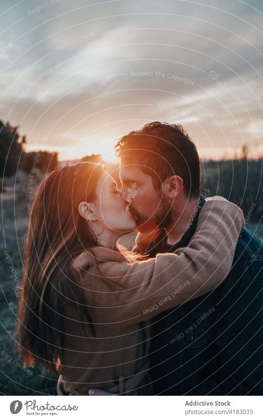 Couple kissing in field with kid at sunset couple family love relationship tender child nature weekend eyes closed happy bonding affection sky together enjoy