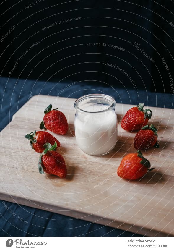 Jar of milk near ripe strawberries on cutting board jar strawberry dairy vitamin protein natural ingredient sweet smoothie glass transparent nutrient