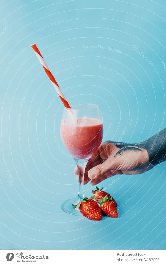 Crop person with glass of sweet refreshing drink smoothie strawberry healthy drink delicious vitamin colorful refreshment yummy ripe tasty organic natural