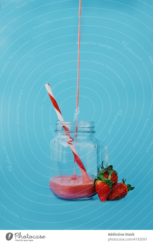 Delicious strawberry smoothie in jar on blue background pour vitamin sweet refreshment yummy fluid ripe flow healthy drink tasty glass organic natural