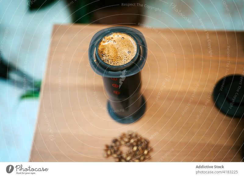 Closeup of coffee grinding machine seen from above isolated cup breakfast drink cafe hot beverage brown background aroma art morning sweet caffeine cream top