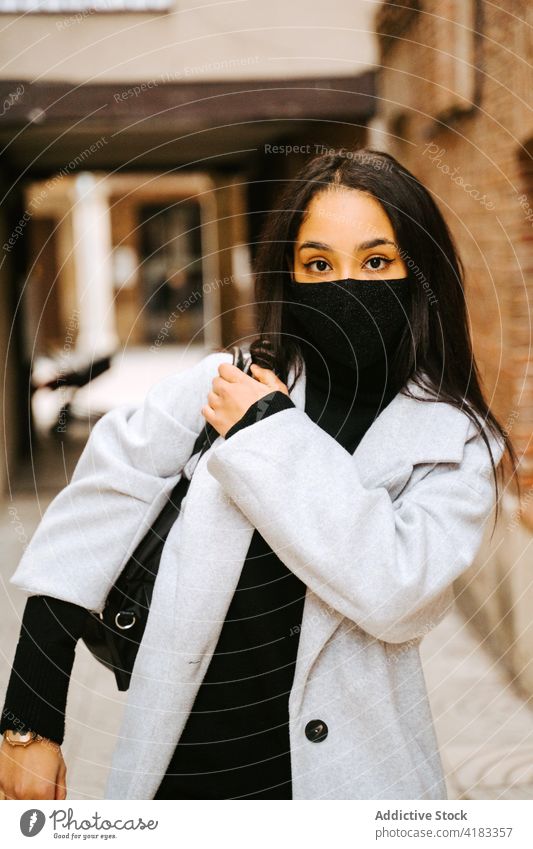 Modern female in mask with bag on street fashion woman coat confident new normal urban pandemic style city carry covid19 coronavirus covid 19 narrow sport