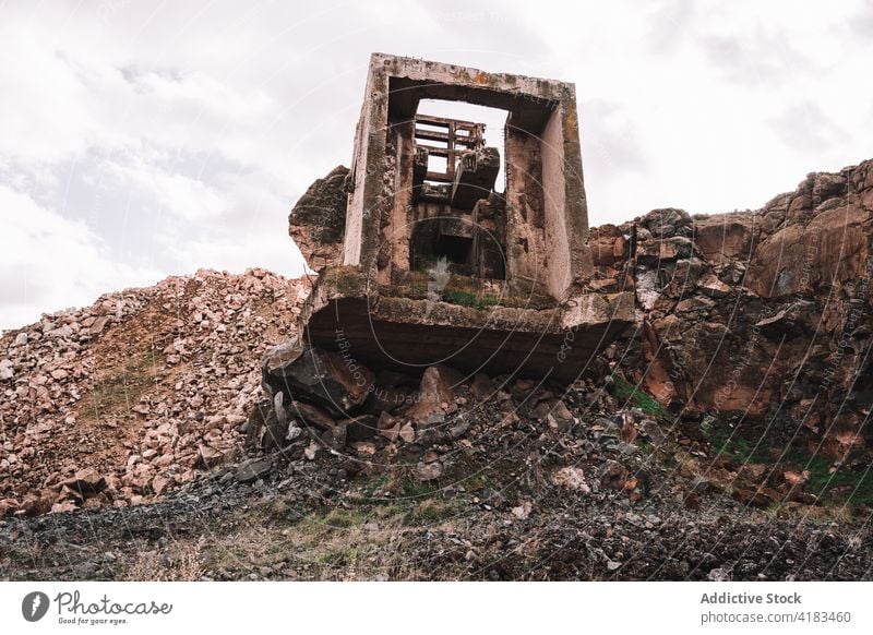 Abandoned quarry with damaged construction under white sky abandoned destroy desolate stone messy weathered cloudy rough open pit cement piece concrete material