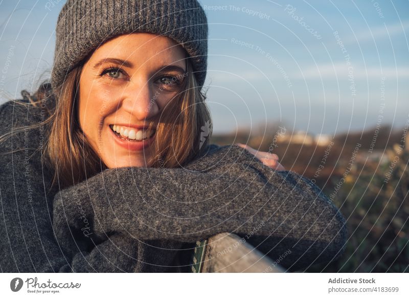 Happy woman in warm knitted wear portrait nature autumn cheerful happy traveler enjoy sunny rest young female lifestyle relax smile trendy positive chill glad
