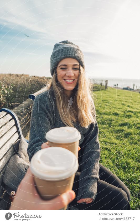 Travelling woman with friend drinking coffee at seaside traveler cup cheerful takeaway clink female together enjoy happy adventure nature rest beverage